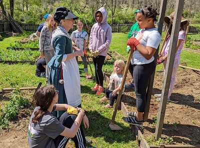 girl scouts in the garden with a farmstead educator